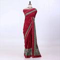 A red cotton saree with green and gold border patterns