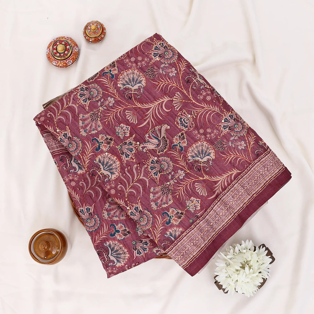 A deep maroon red saree with intricate gold and beige floral patterns