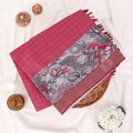 A folded red and grey printed saree features a sage red body with brown borders