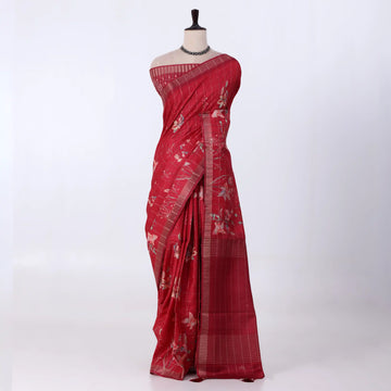 A red tussar saree with white floral prints and a striped border