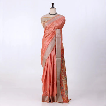 A peach-colored ilk saree with a beige border and a patterned orange and gold pallu