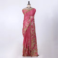 A pink saree with gold and white floral embroidery