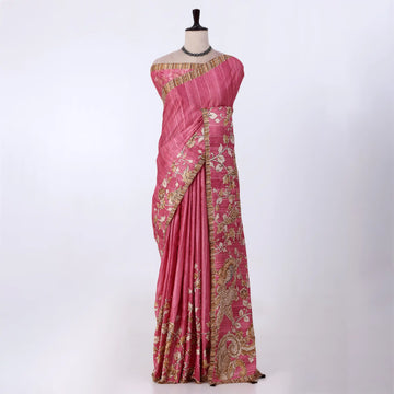 A pink saree with gold and white floral embroidery