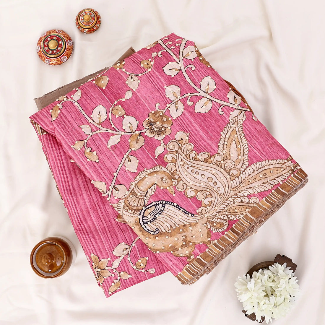A pink saree with gold and white floral embroidery