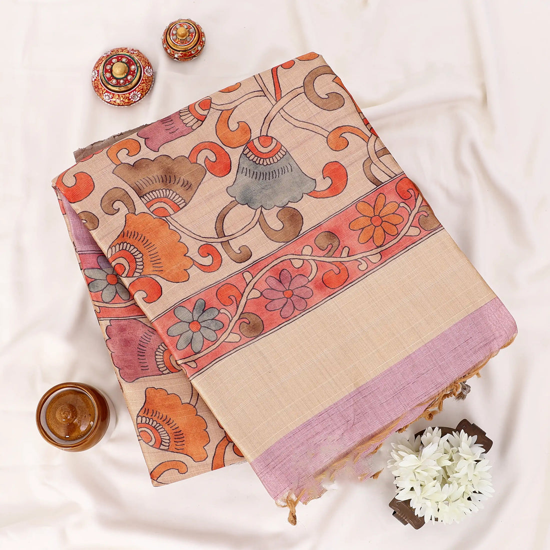 A pink silk saree with a beige border and a rust-orange patterned pallu