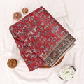 A folded red fabric garment or textile with a detailed multicolor printed pattern