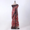 A red and black printed saree features a red base with black and white floral patterns and a solid black border.