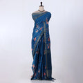 A blue patterned saree with pink floral motifs and striped borders
