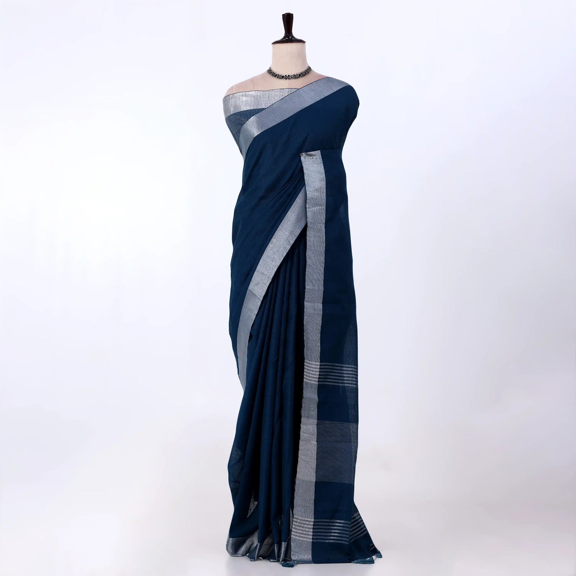 A dark navy blue saree with a silver woven border
