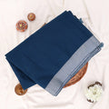 A folded navy blue saree with a light gray border