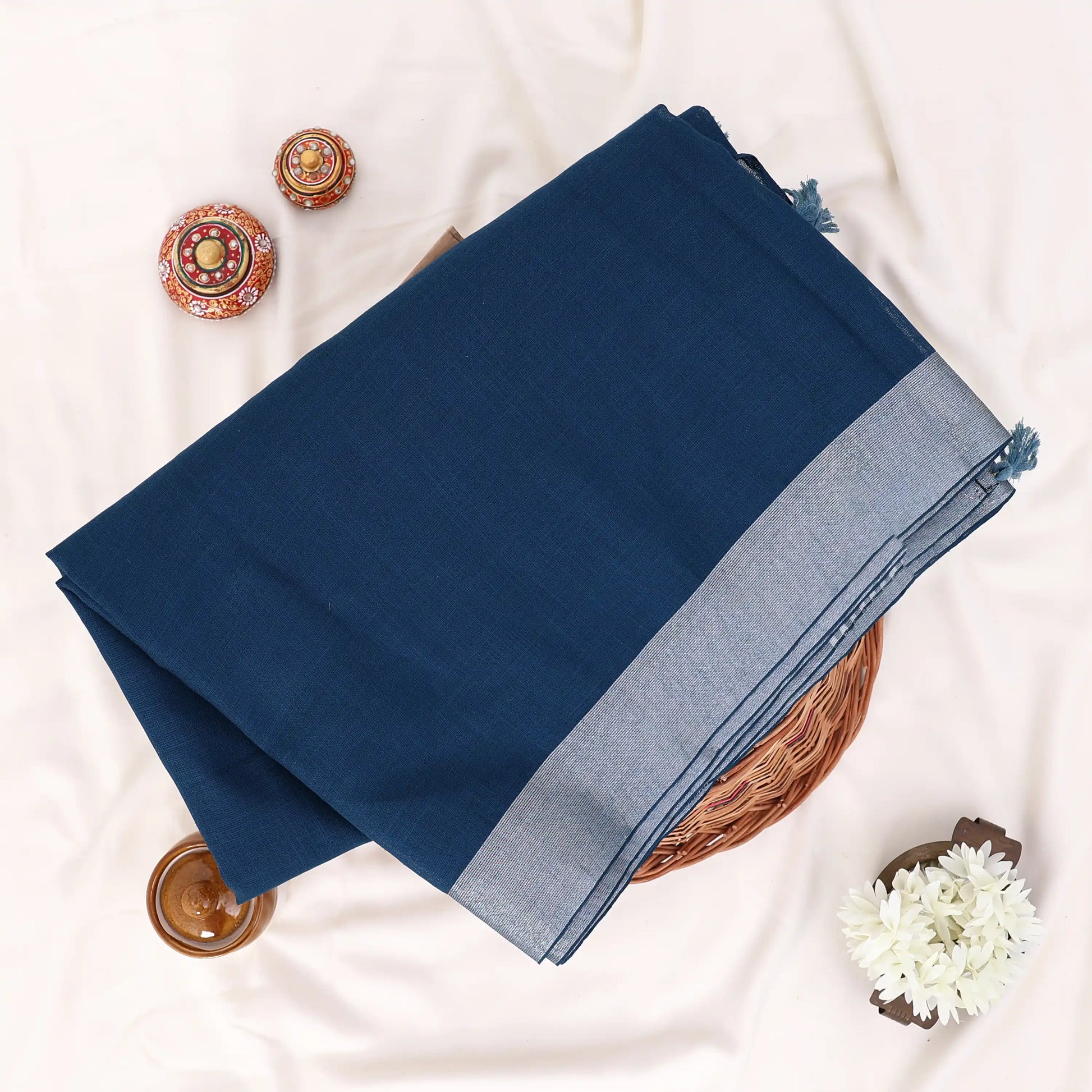 A folded navy blue saree with a light gray border