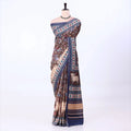 A brown and beige printed saree with blue borders
