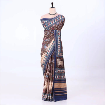 A brown and beige printed saree with blue borders