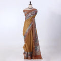 A mustard yellow and brown printed saree featuring a floral patterned border and pallu