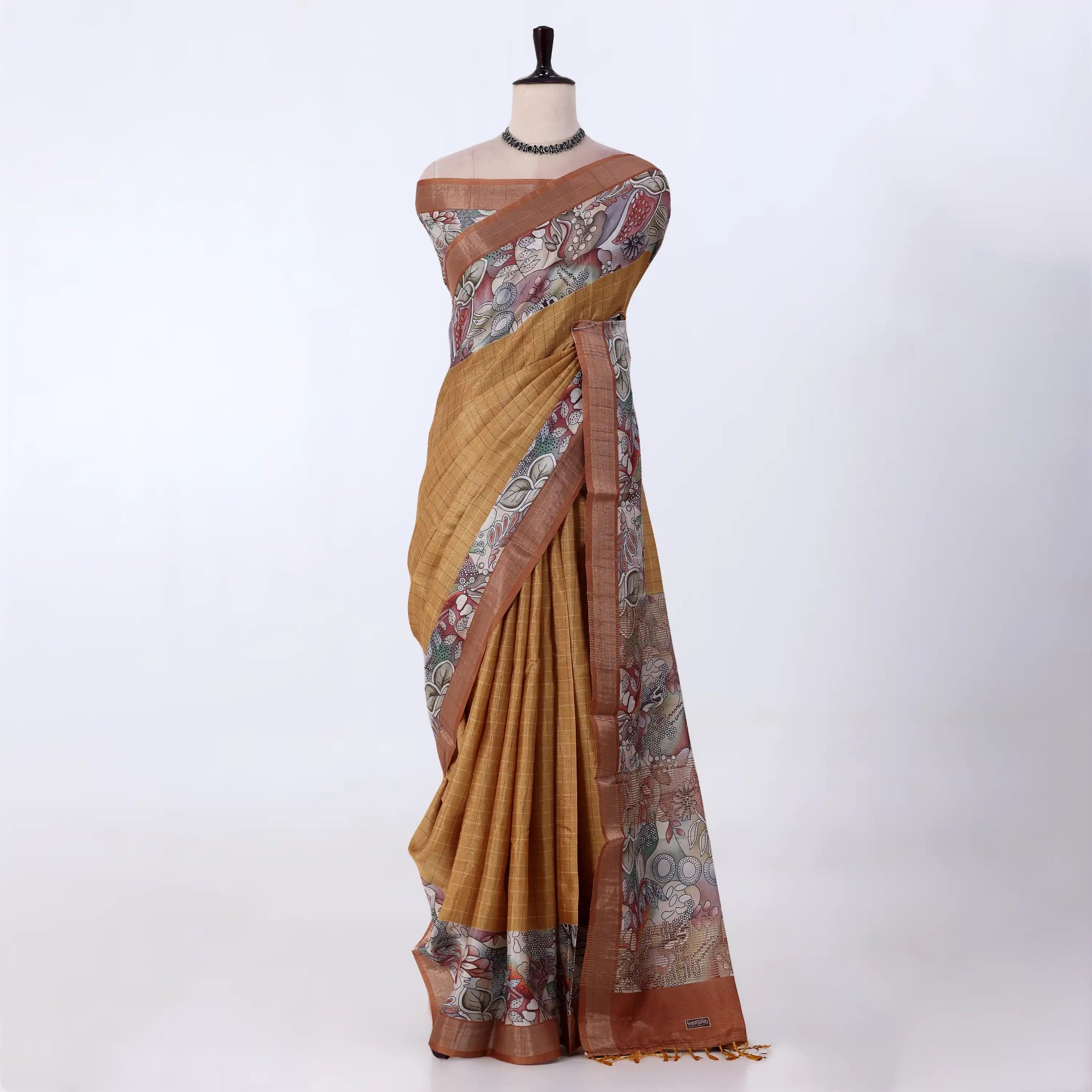 A mustard yellow and brown printed saree featuring a floral patterned border and pallu