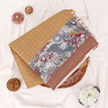 A folded patterned saree with tan grid-patterned section, a dusty rose border, and a central multicolor floral and paisley print