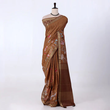 A brown tussar saree with floral prints and a striped border