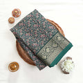 Green art silk saree with floral paisley jaal pattern and broad zari border folded flat lay view
