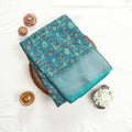 Art silk saree with floral vine jaal pattern and silver zari striped border in green folded top view display