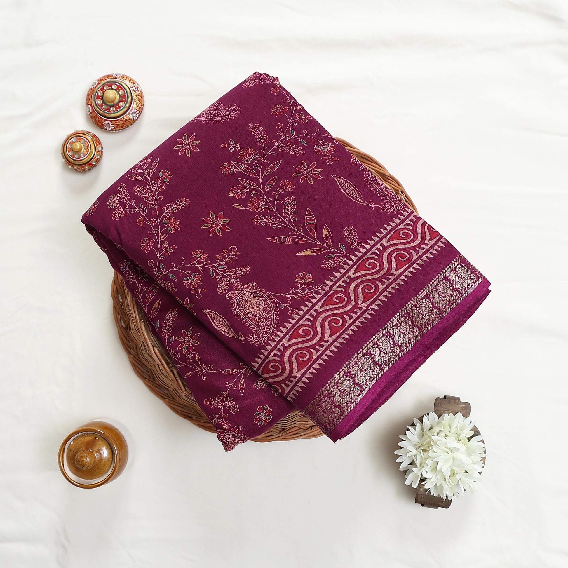 Art silk saree with floral vine and paisley motifs in purple folded flat lay product view