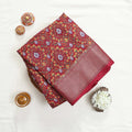 Art silk saree with floral vine jaal pattern and zari striped border in red folded top view display