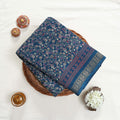 Art Silk saree with delicate floral vine print and zari border in teal top view folded display