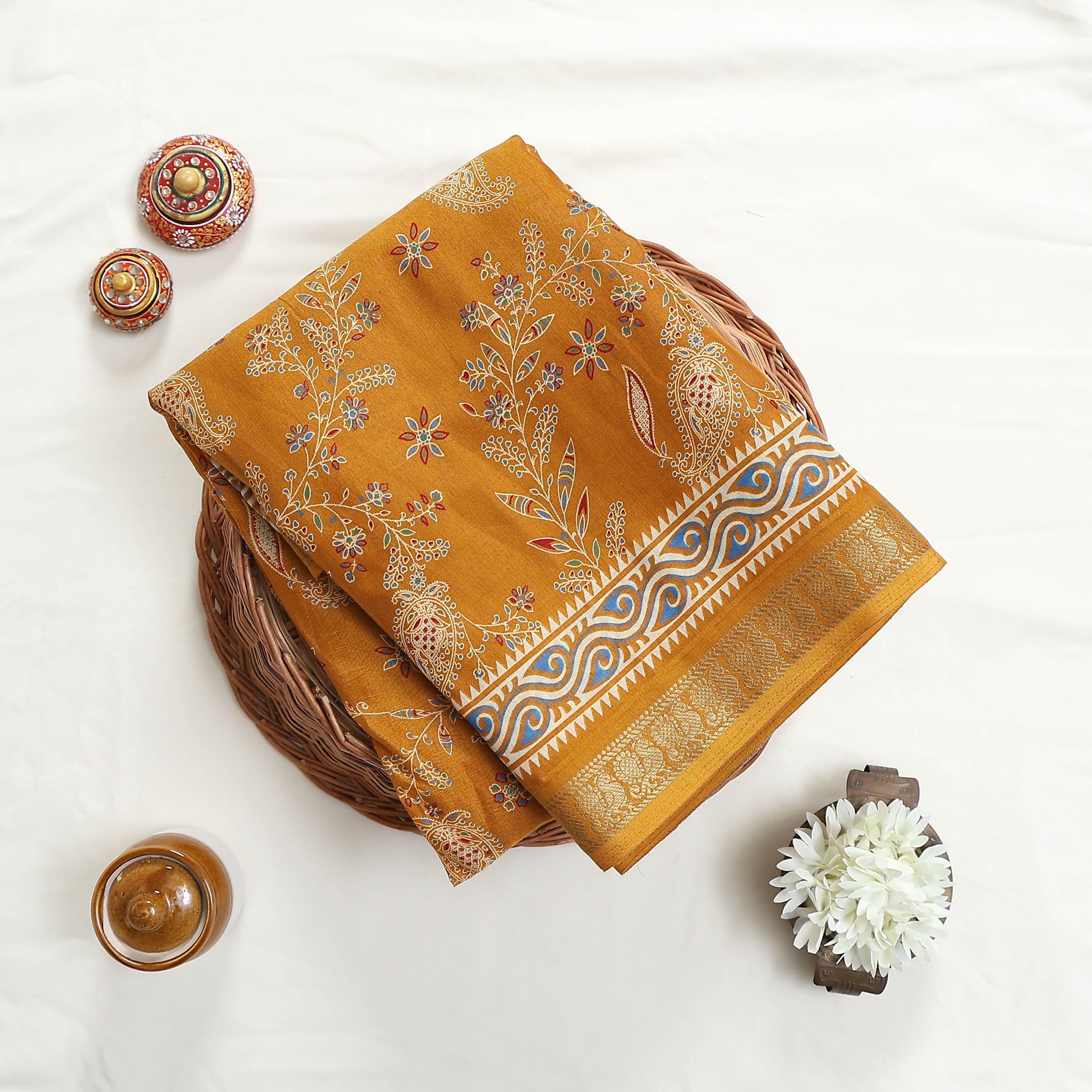 Art silk saree with floral vine and paisley motifs in yellow folded flat lay product view