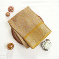 Yellow art silk saree with floral paisley jaal pattern and broad zari border folded flat lay view