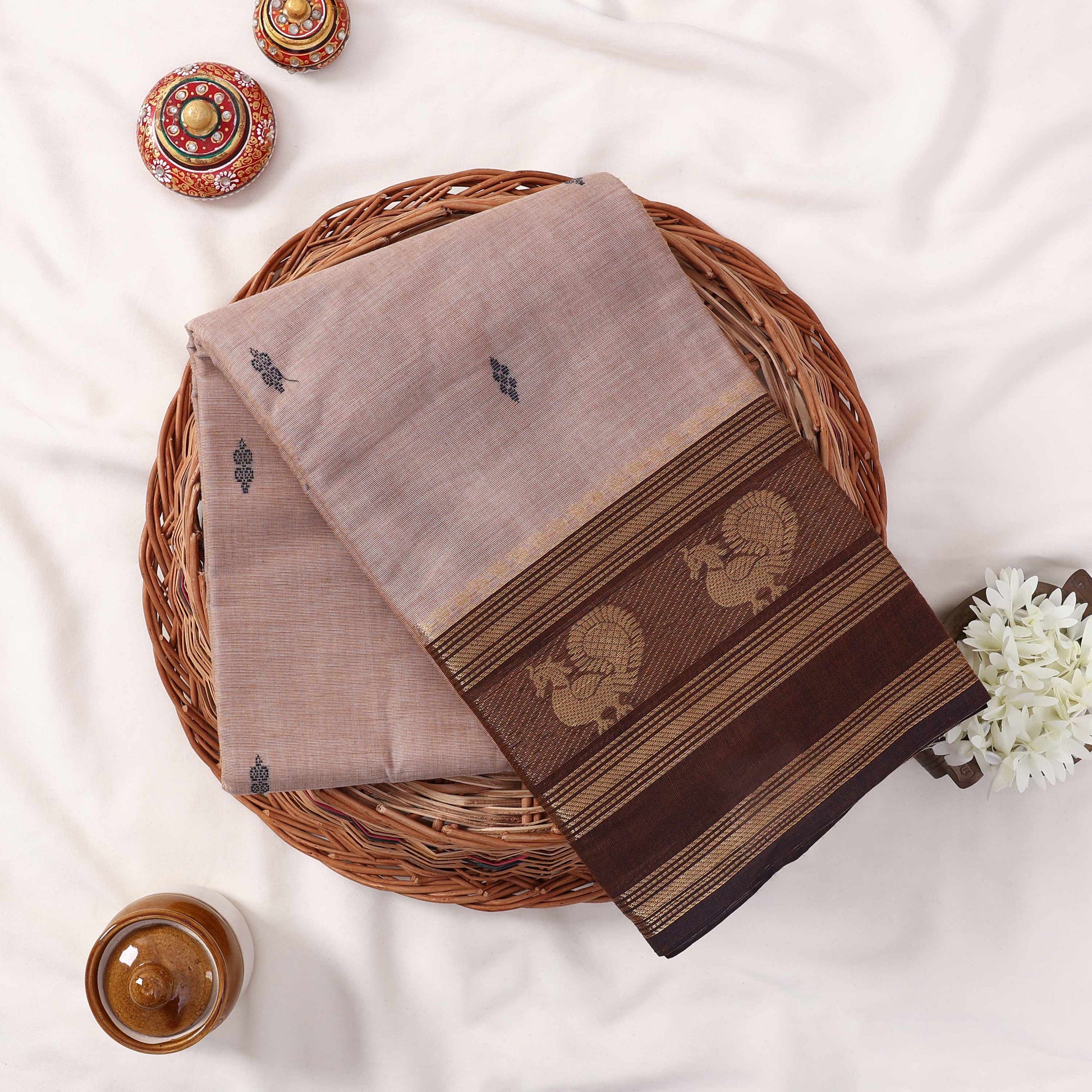 Kanchi Cotton Saree With Brown Zari Border And Subtle Motifs In Beige Neatly Folded Top View Display
