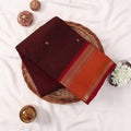 Kanchi Cotton Saree With Brown Body Orange Zari Border And Gold Butta Motifs Folded Top View With Decorative Accents
