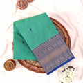 Kanchi Cotton Saree With Turquoise Green Body And Royal Blue Zari Border Folded Flat Lay Display View
