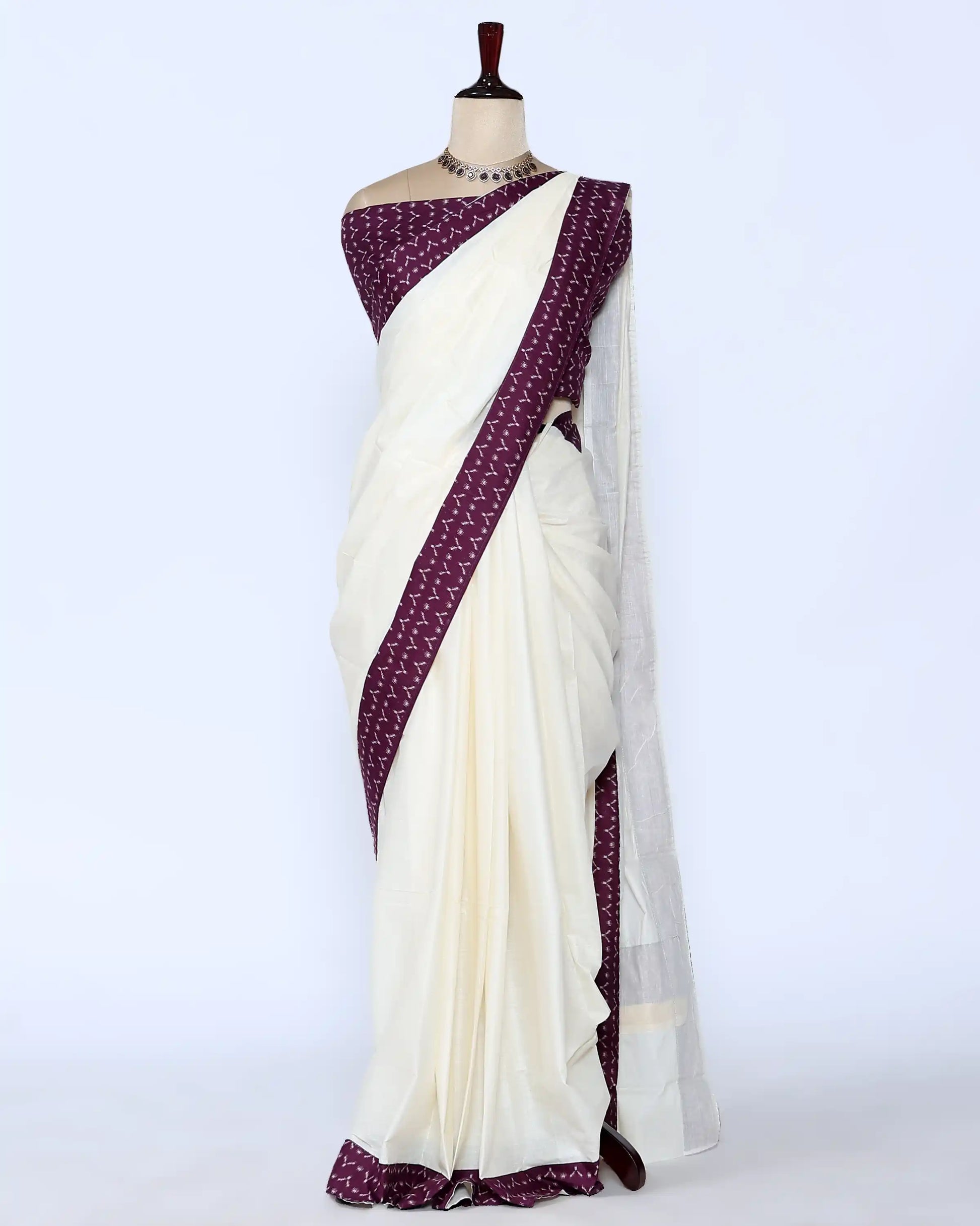 An off-white/cream saree featuring a deep purple border with a white geometric pattern - full view