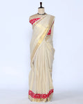A cream-colored kerala saree with a red and white patterned border and matching blouse - full view