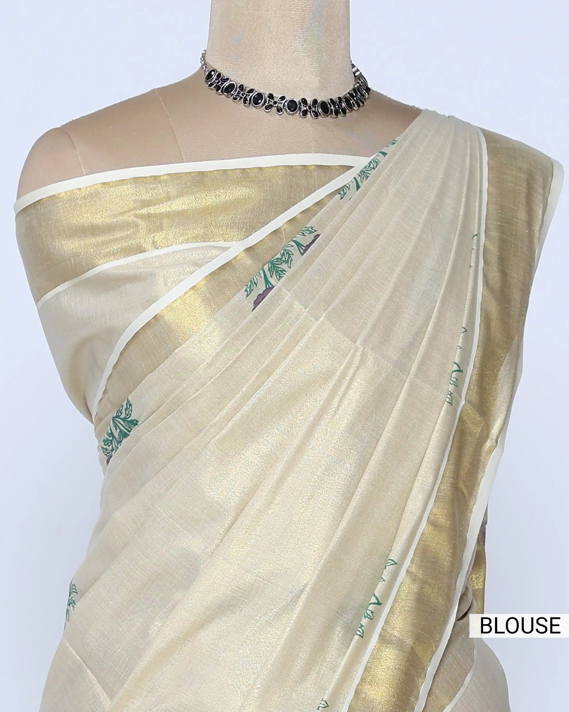 A cream-colored kerala saree with a metallic gold border and purple floral embroidery near the hem blouse view
