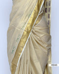 A cream-colored kerala saree with a metallic gold border and purple floral embroidery near the hem head view