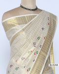 A cream-colored kerala saree with gold zari stripes and small colorful floral motifs, blouse view