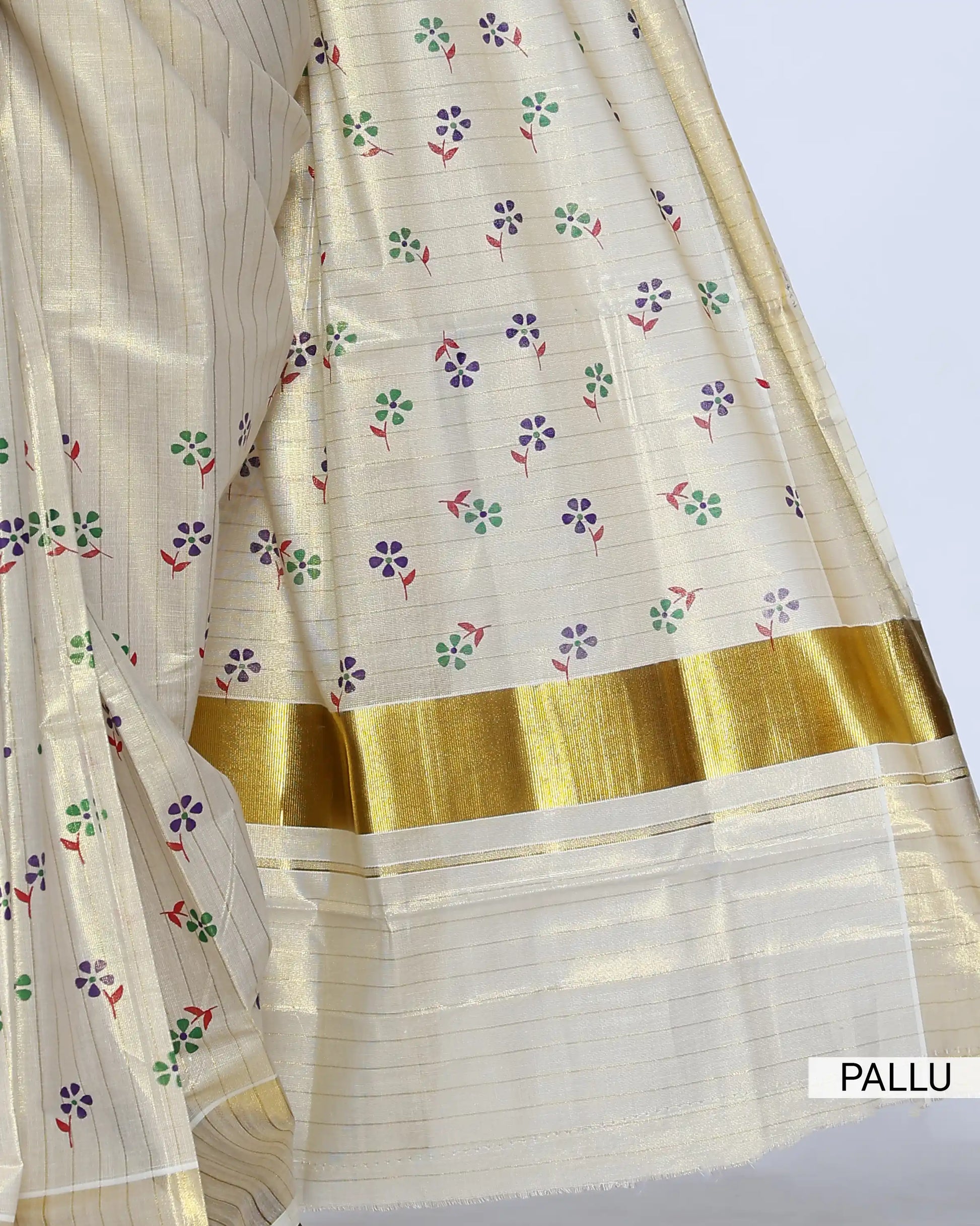 A cream-colored kerala saree with gold zari stripes and small colorful floral motifs, pallu view