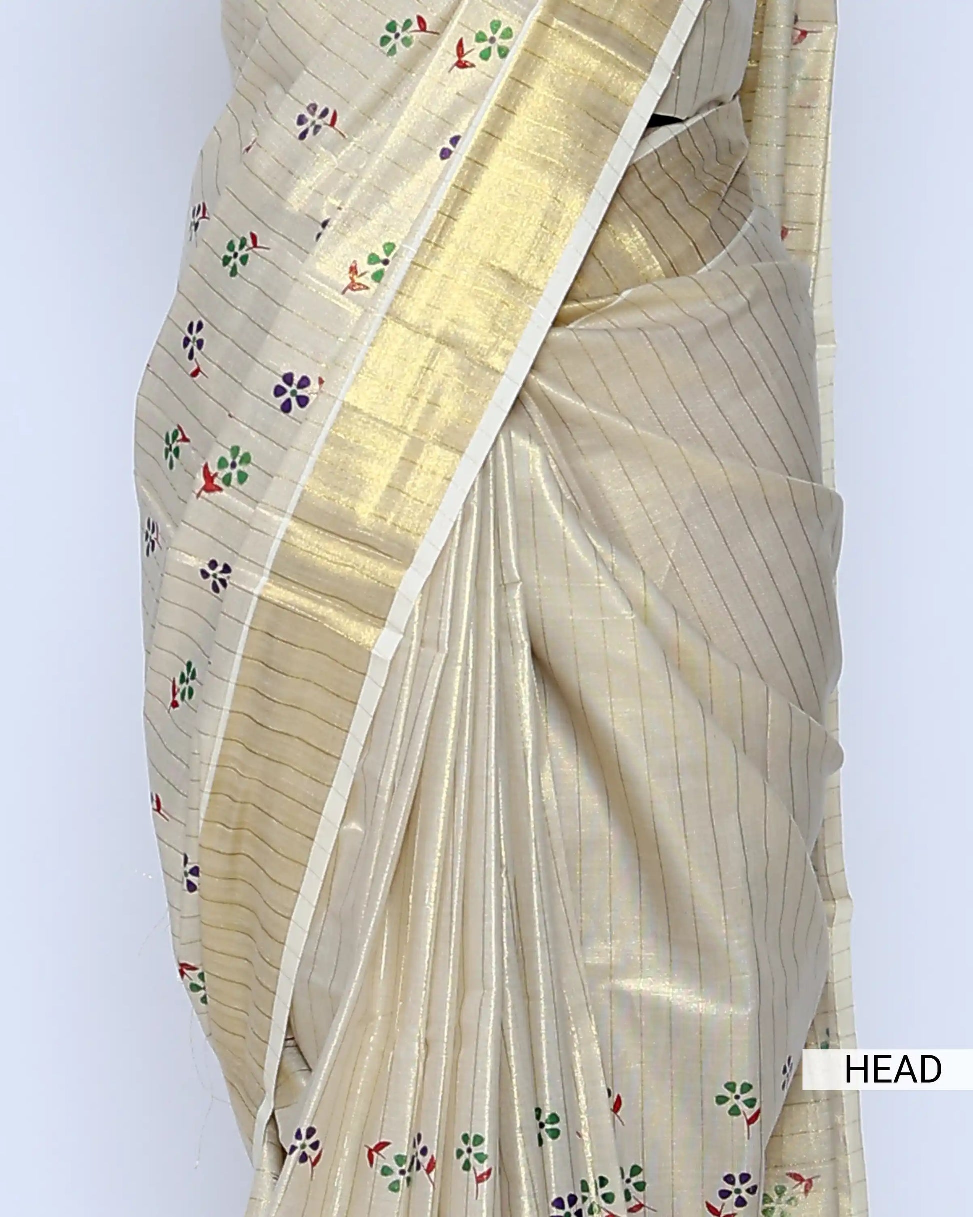 A cream-colored kerala saree with gold zari stripes and small colorful floral motifs, head view