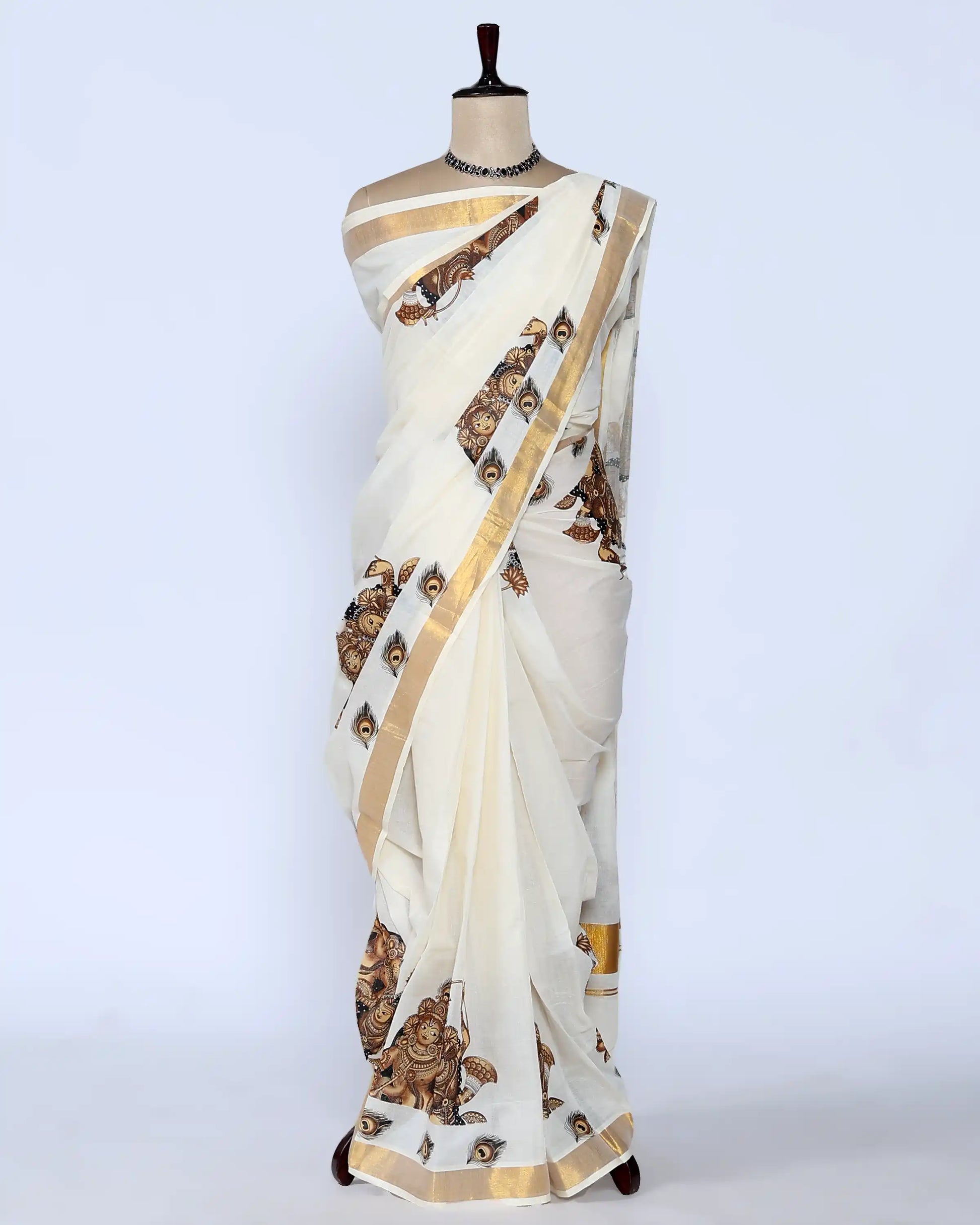 An off-white saree with gold zari borders and brown printed motifs full view