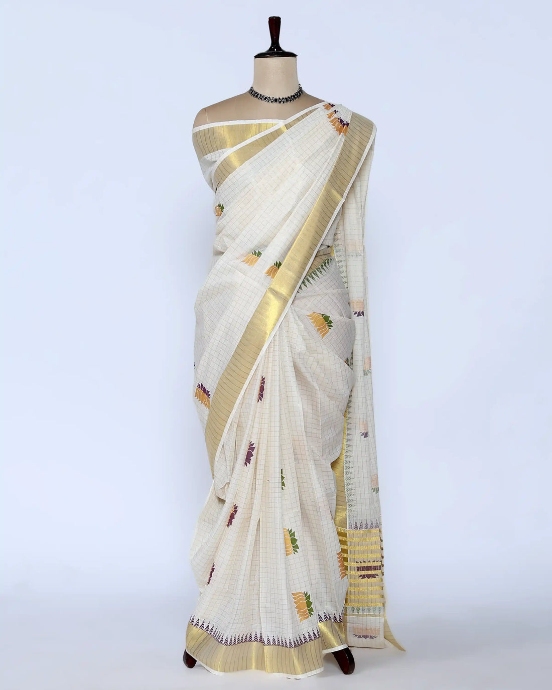 An off-white kerala saree with gold zari borders and small multicolor floral motifs - full view