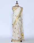 An off-white kerala saree with gold zari borders and small multicolor floral motifs - full view
