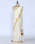 An off-white cotton saree with gold zari borders and small gold dots full view