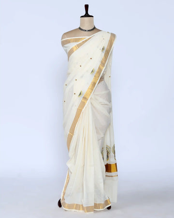 An off-white cotton saree with gold zari borders and small gold dots full view