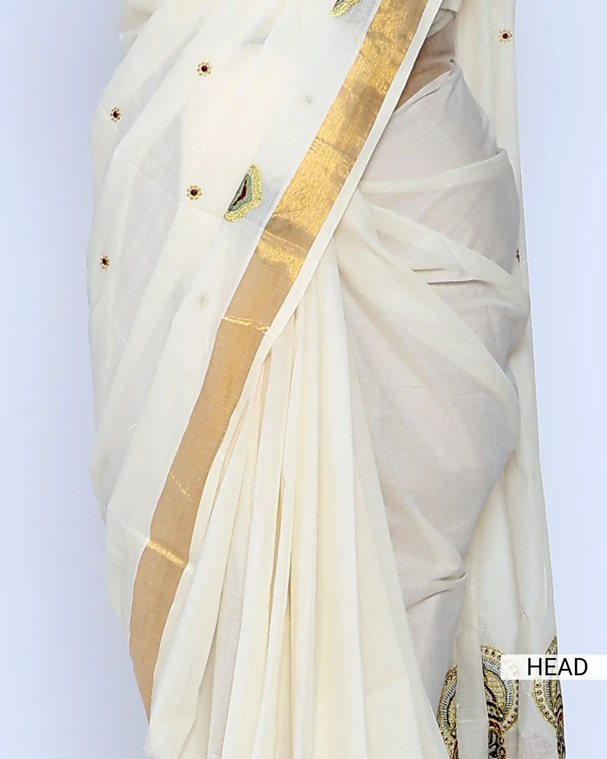 An off-white cotton saree with gold zari borders and small gold dots head view