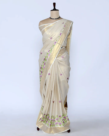 A cream-colored Kerala saree with purple and green floral embroidery full view