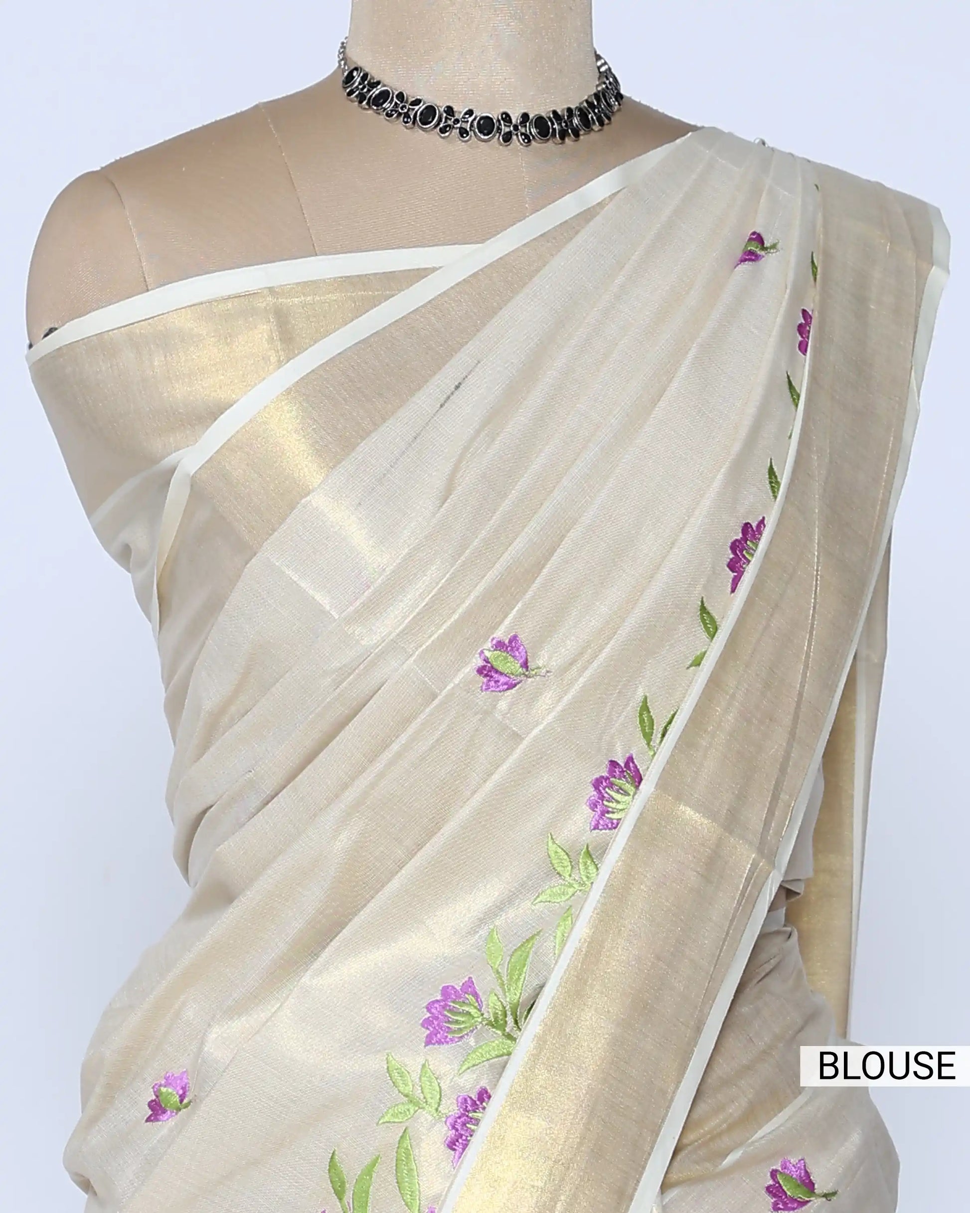 A cream-colored Kerala saree with purple and green floral embroidery Blouse view