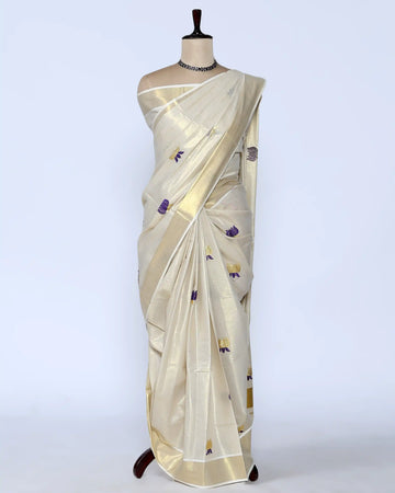 A cream-colored silk saree with small purple and gold floral motifs - full view
