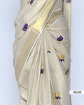 A cream-colored silk saree with small purple and gold floral motifs - head view