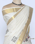 An off-white cotton saree with a wide gold border and small black and red floral motifs - blouse view