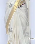 An off-white cotton saree with a wide gold border and small black and red floral motifs - pallu view